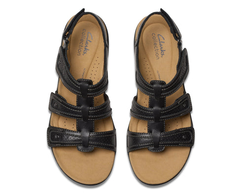Overhead view of pair of black leather sandals with adjustable straps and a tan sole.