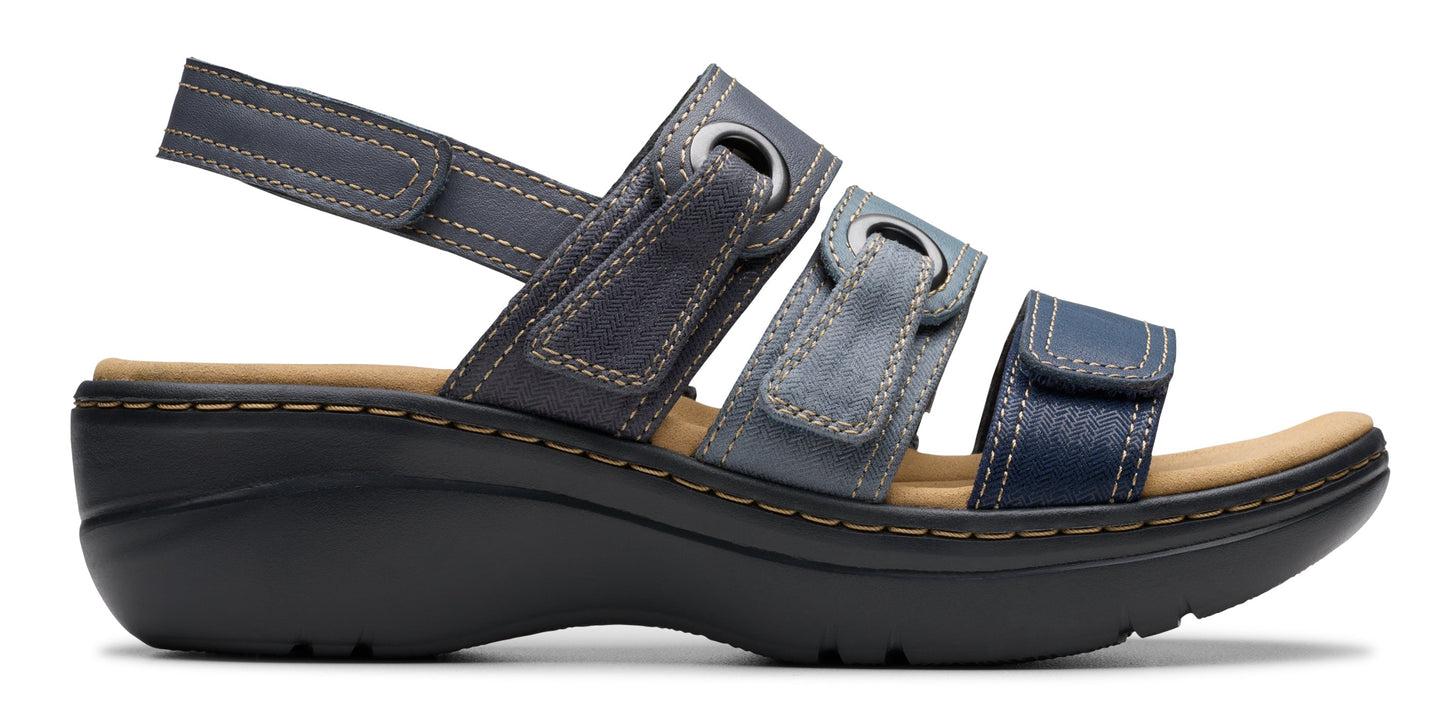 A sandal with three straps in varying shades of blue, with a tan insole and a black platform sole.