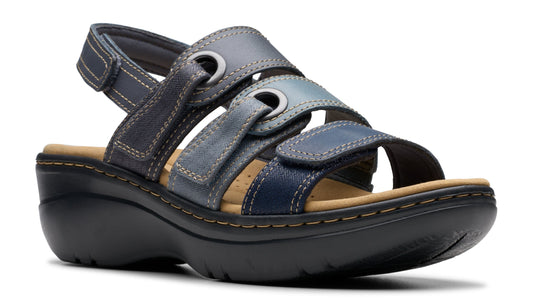A women's sandal with blue-toned leather straps, adjustable velcro closures, and a low, black wedge heel.