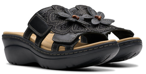 Black leather sandal with a velcro strap and flower embellishment.
