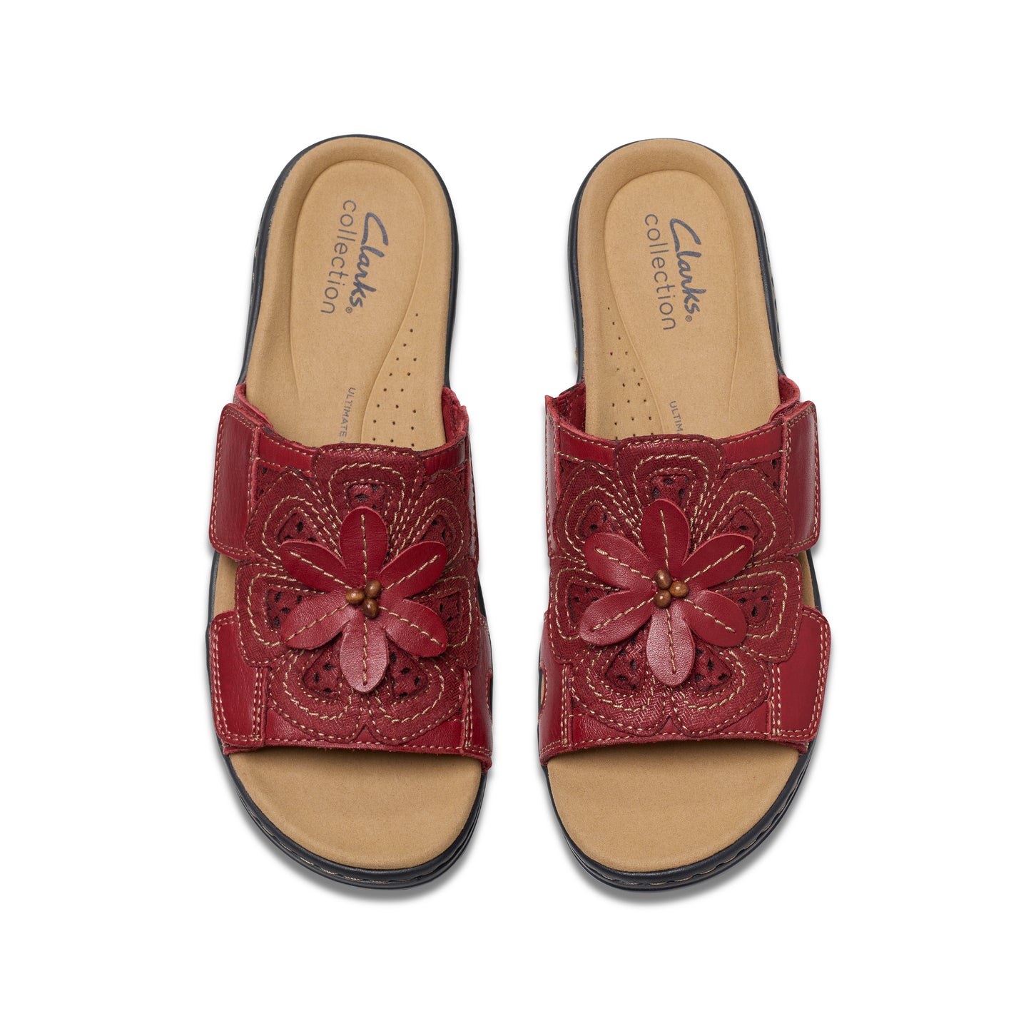 Pair of red leather sandals with flower accent.