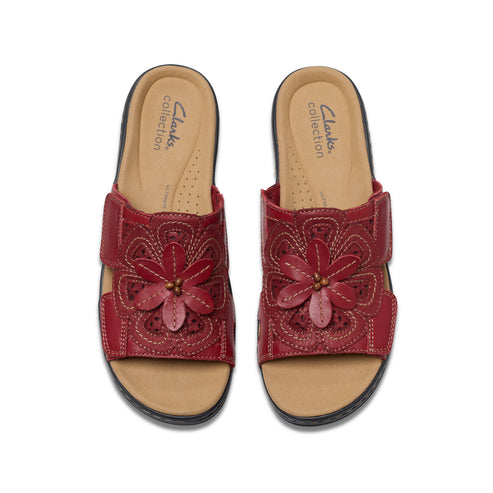 Pair of red leather sandals with flower accent.