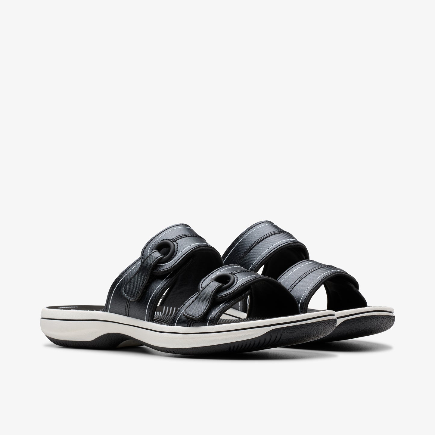 Pair of black, open-toe sandals with adjustable velcro straps and white soles.