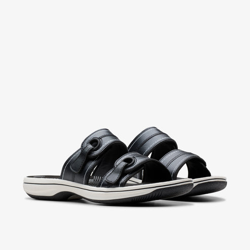 Pair of black, open-toe sandals with adjustable velcro straps and white soles.