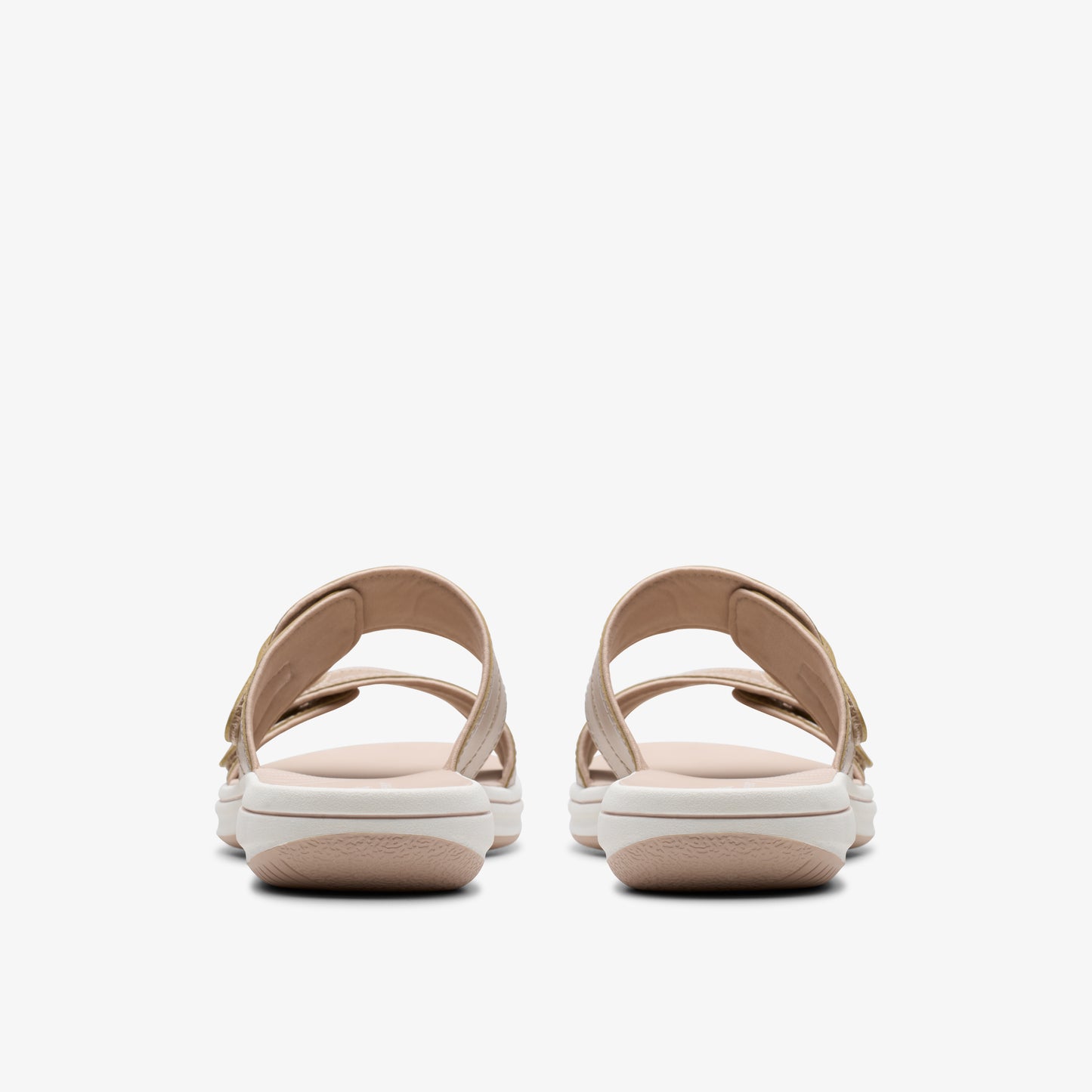 Rear view of two beige double-strap sandals with a white sole.