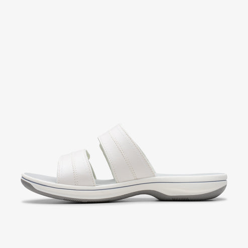 White sandal with two straps and a gray sole, seen from the side.
