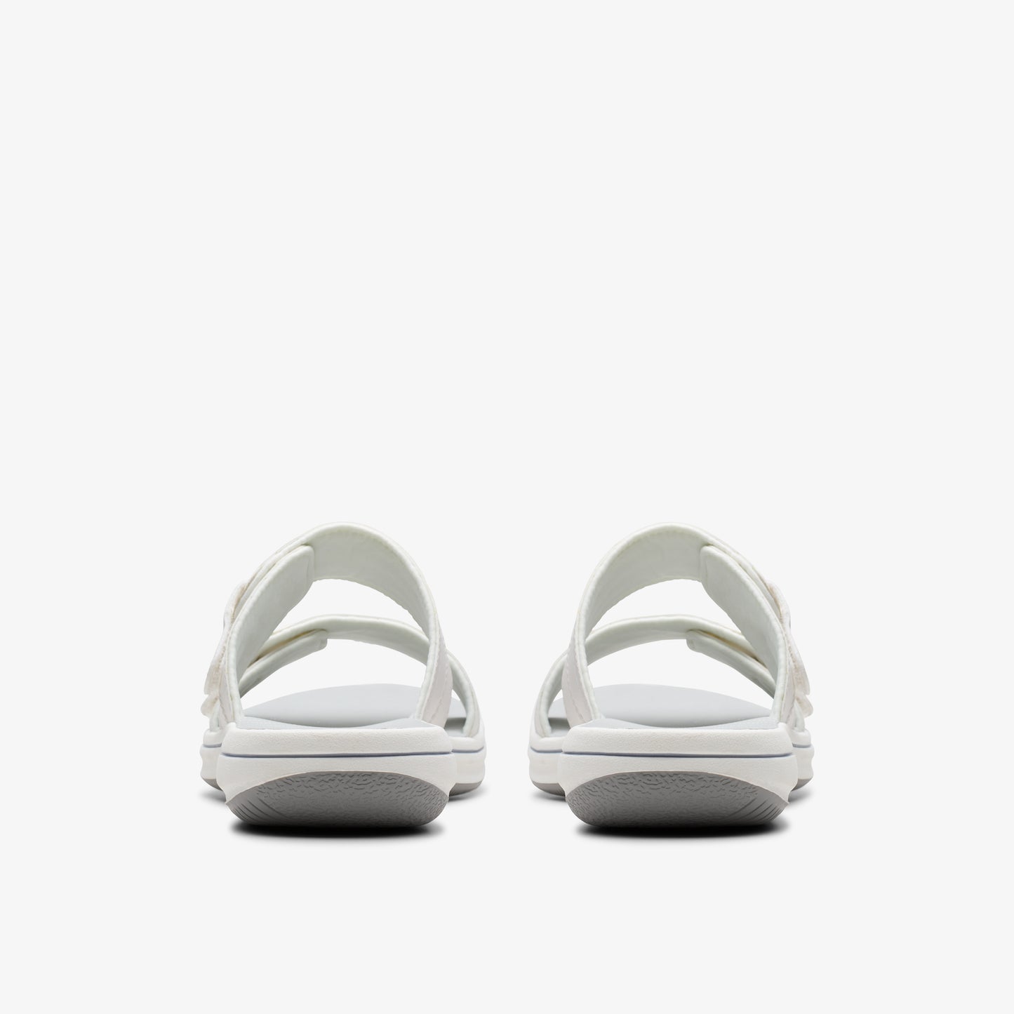 Two white slide sandals with two straps, viewed from the back.