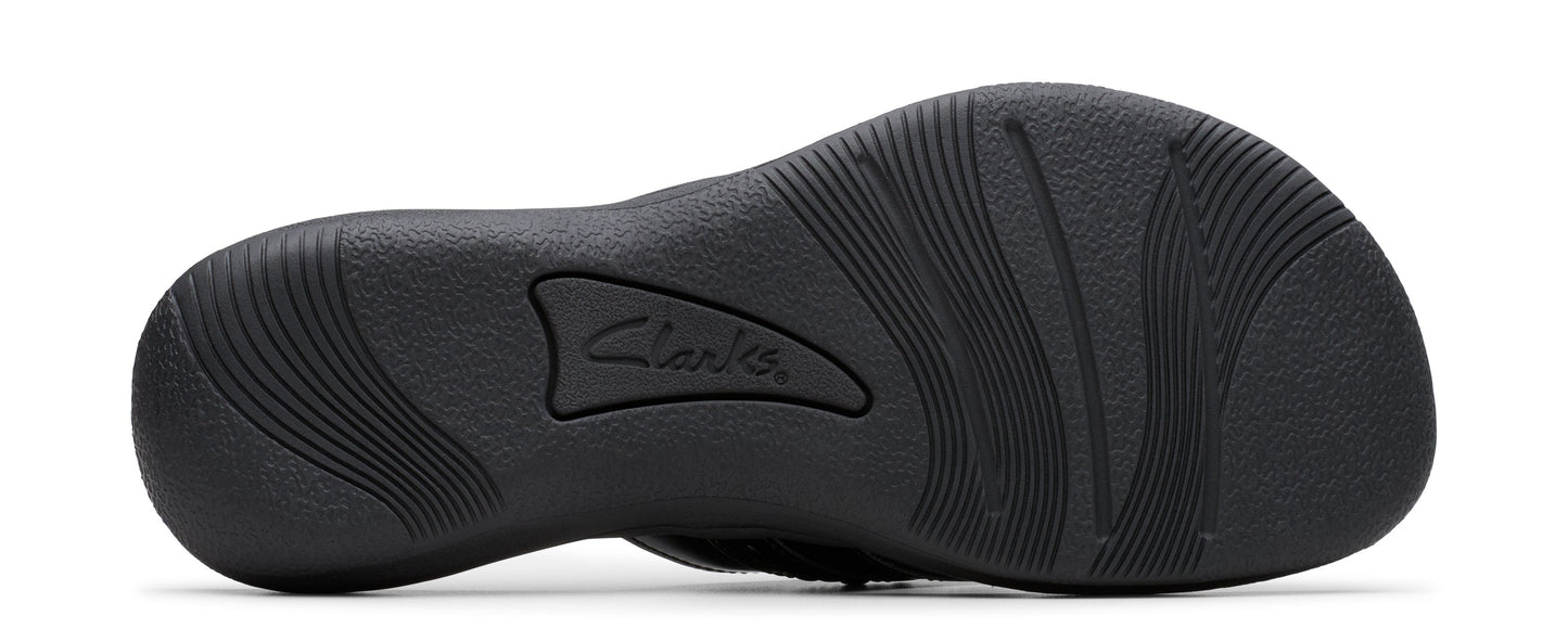 Sole of a dark-colored shoe with curved treads and the word "Clarks".