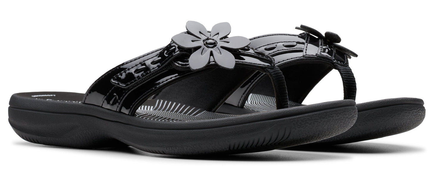 Black patent leather sandals with flower detail.