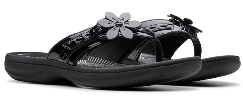 Black patent leather sandals with flower detail.