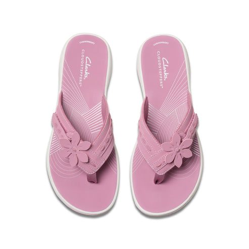 Pink flower-embellished flip-flops with white soles, top view.