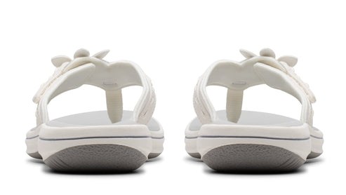 A pair of white, wedge thong sandals showing the back.