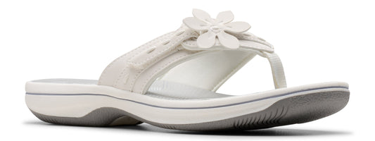 A white sandal with a flower decoration.