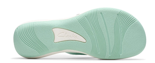 Light green shoe sole with wavy patterns and a white logo in the center.