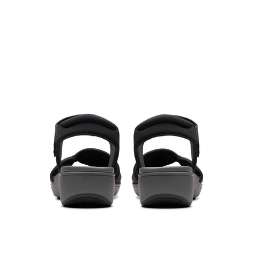 Two identical black wedge sandals facing away, adjustable hook and loop straps.