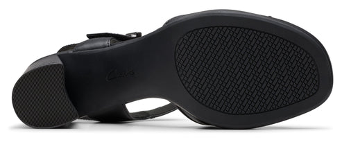 Bottom view of a black heeled sandal with a textured sole.