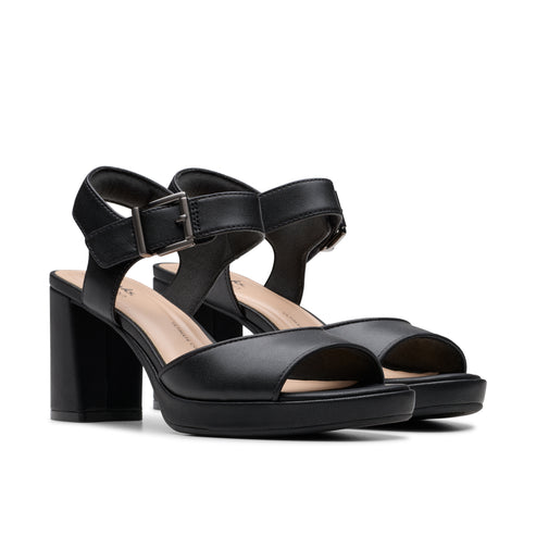 Pair of black heeled platform sandals with ankle straps.