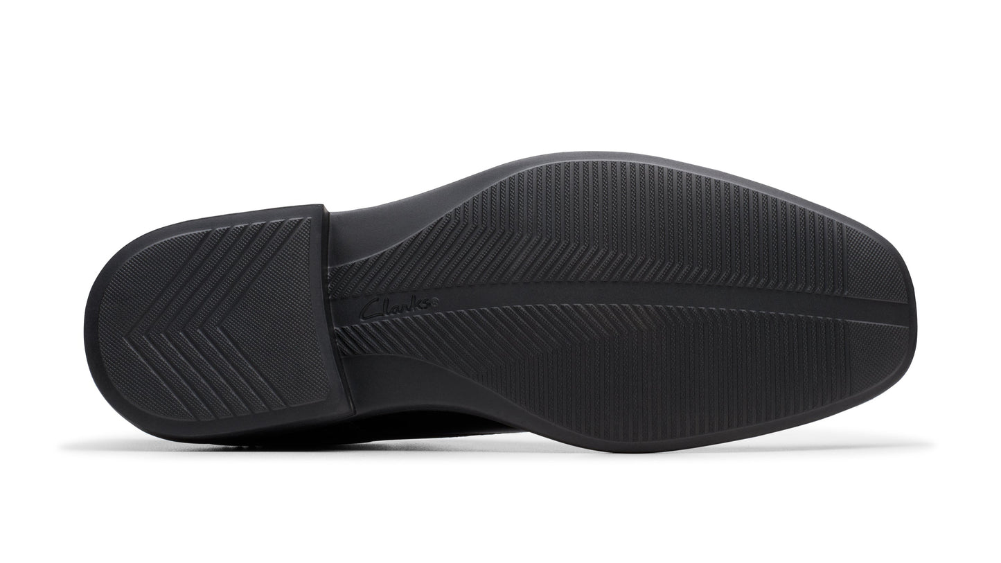Bottom view of a black dress shoe showing the sole with a textured pattern.