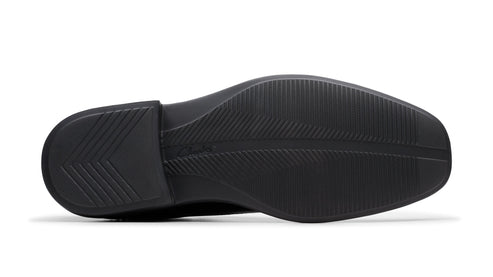 Bottom view of a black dress shoe showing the sole with a textured pattern.