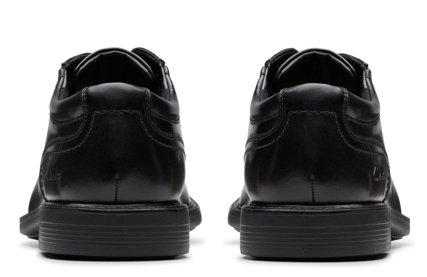 Pair of black leather dress shoes, viewed from the back.