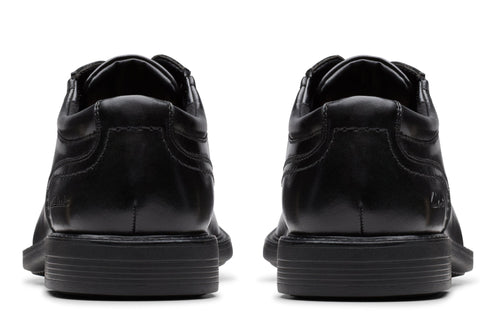 Pair of black leather dress shoes, viewed from the back.