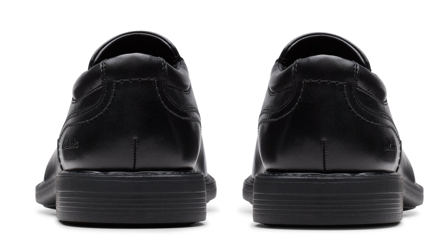 Pair of black leather dress shoes from the rear with visible stitching.