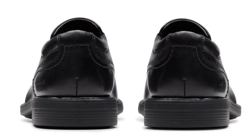 Pair of black leather dress shoes from the rear with visible stitching.