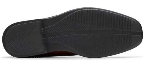 Bottom view of a shoe showcasing a black sole with a linear pattern.