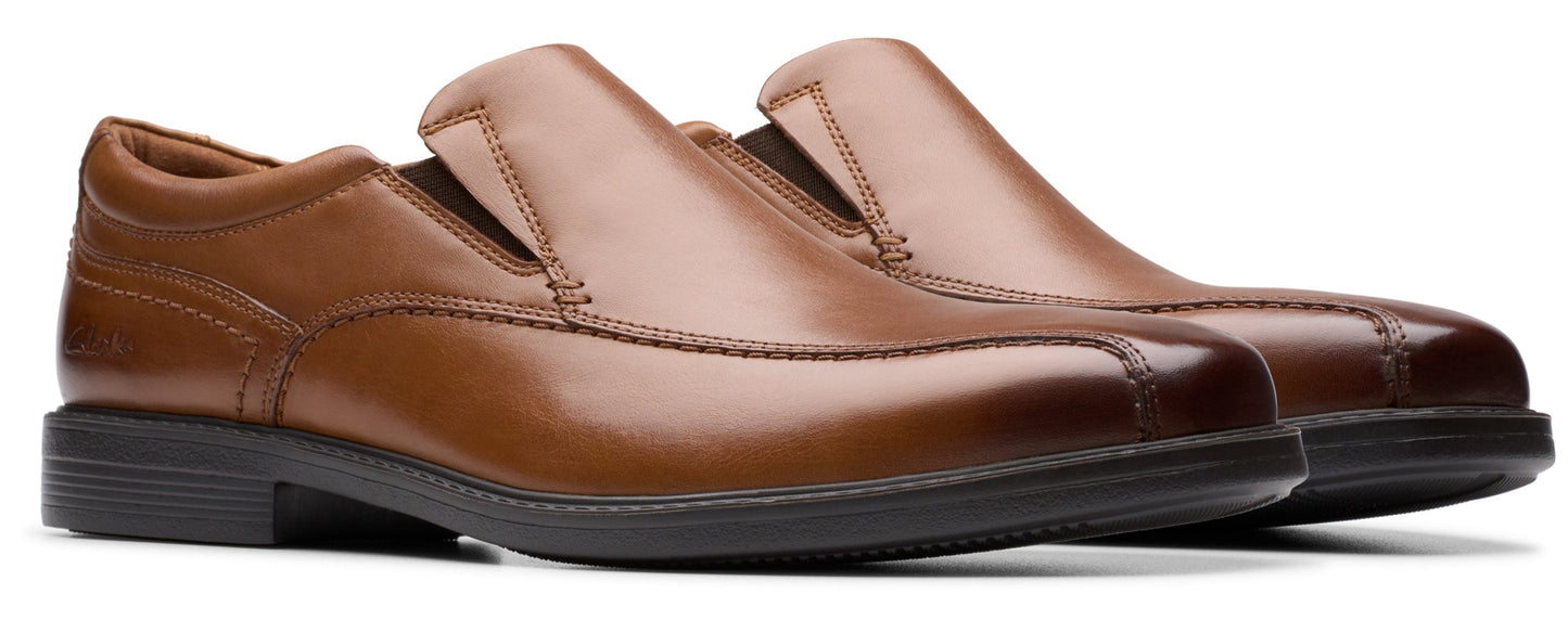 A pair of brown leather slip-on dress shoes with black soles.