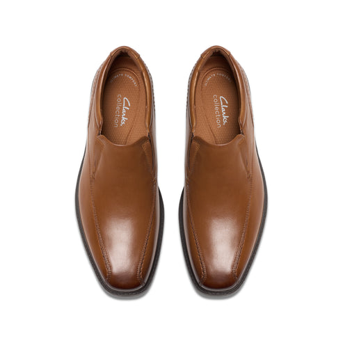 A pair of brown leather slip-on dress shoes, top view.