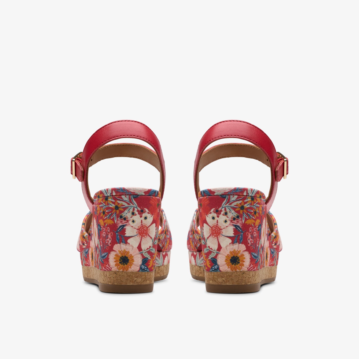 Back view of two red platform sandals with floral pattern and ankle straps.
