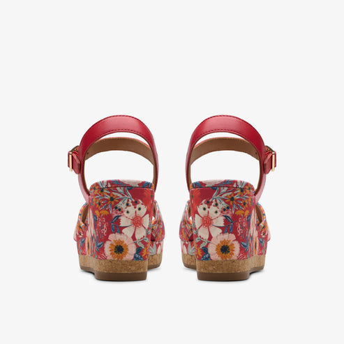 Back view of two red platform sandals with floral pattern and ankle straps.
