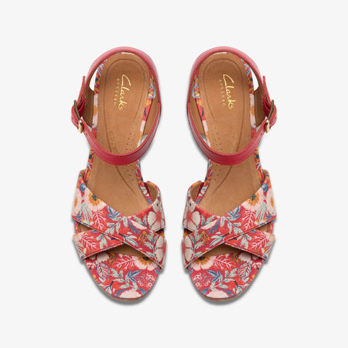 Overhead view of floral print open-toe sandals with red ankle straps.