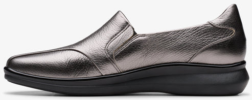 A slip-on pewter colored leather shoe with a low black heel.