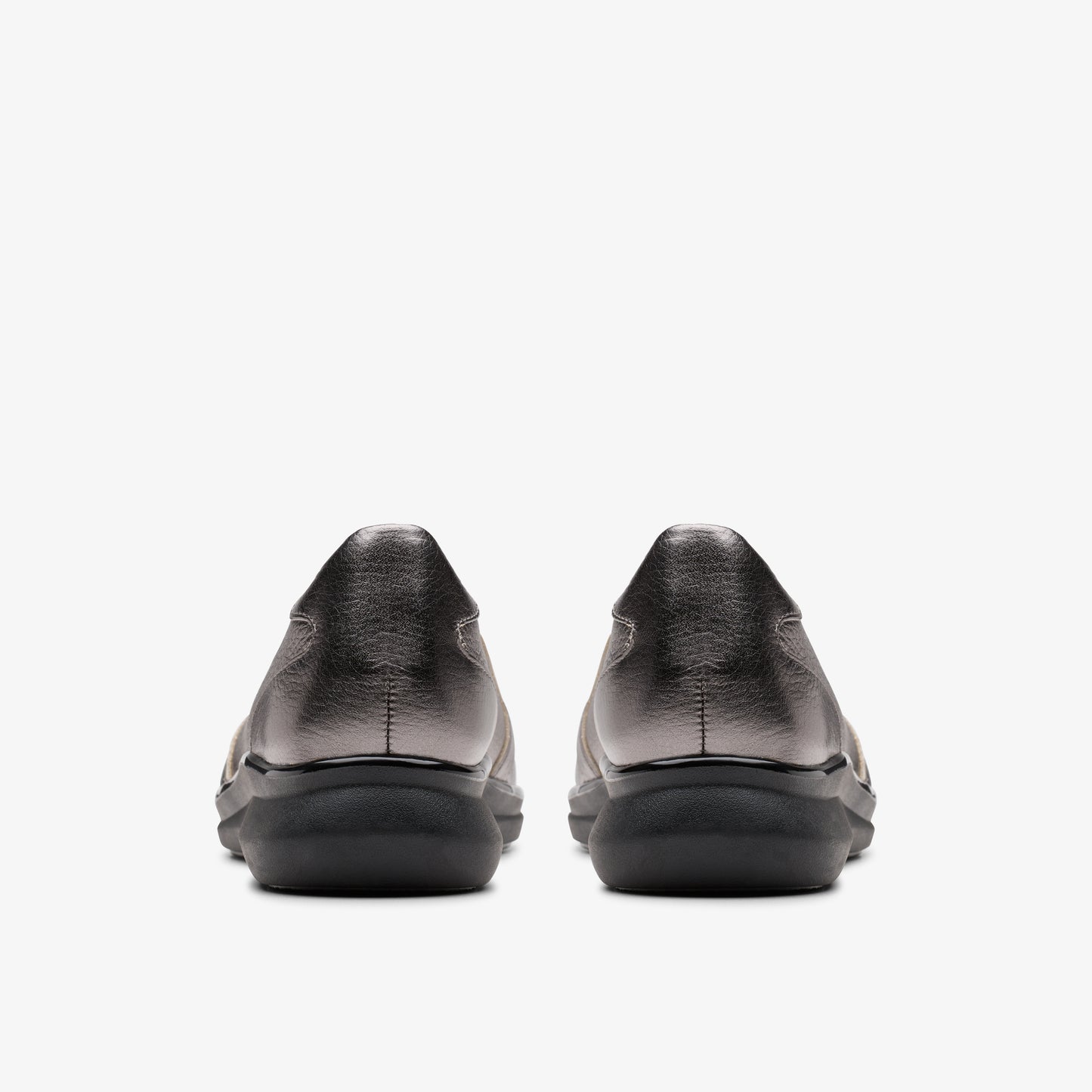 Pair of low-heeled metallic silver shoes, rear view.