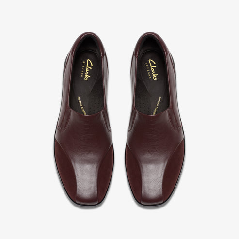 Top-down view of two reddish-brown leather shoes with elastic openings and rounded square toes.