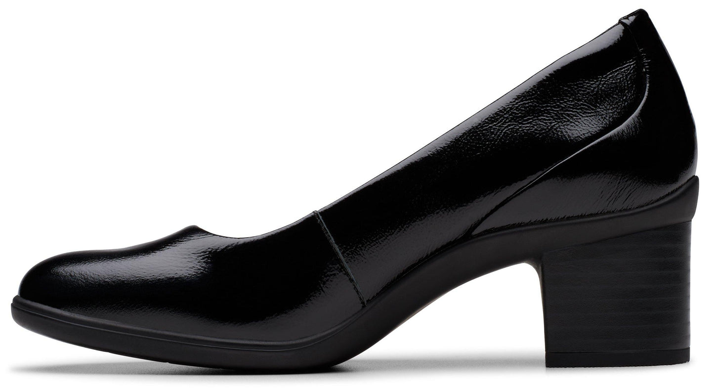 Side view of black patent leather heeled pump with round toe and block heel.