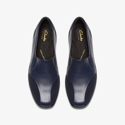 Top-down view of navy blue slip-on leather shoes with square toes and cushioned insoles.