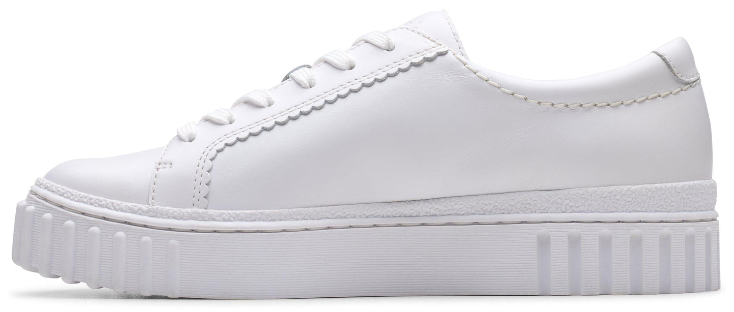 A white sneaker with a ridged sole and a scalloped lace line.