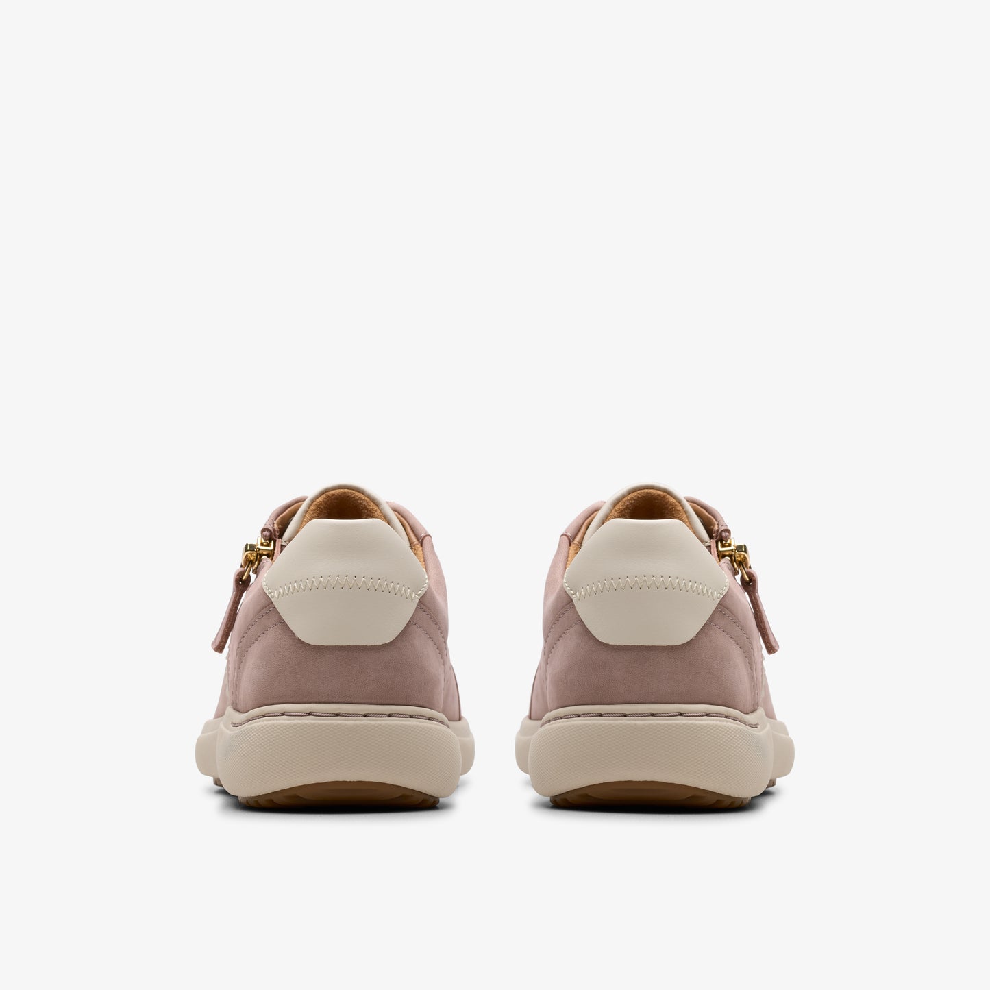 Rear view of pink suede sneakers with off-white heel patch and beige sole.
