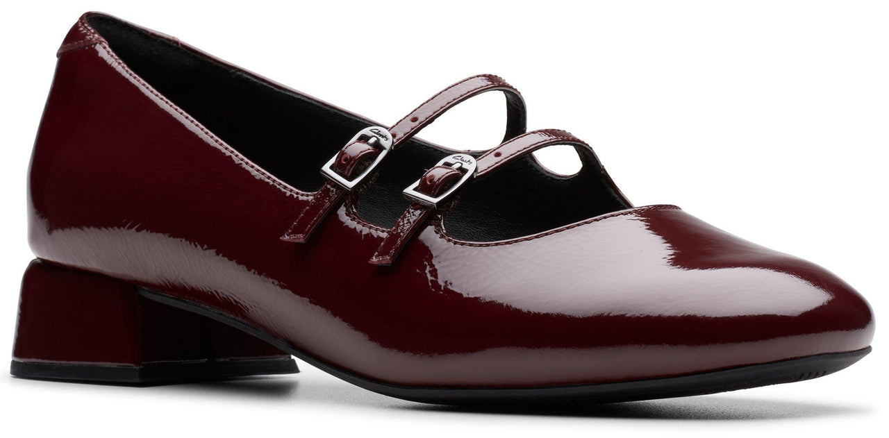 Burgundy patent leather Mary Jane shoe with two straps and buckle closure.