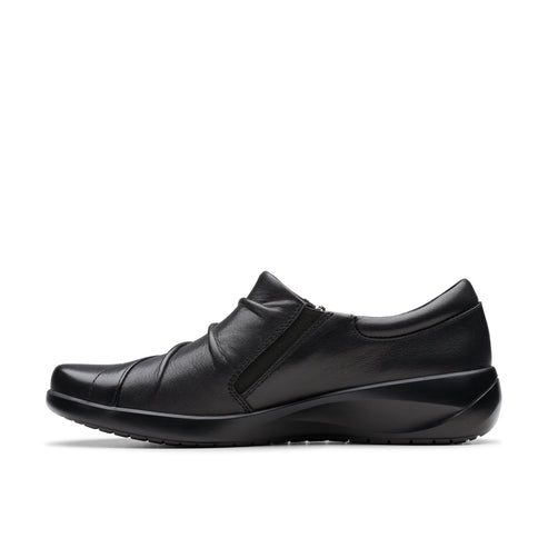 Black leather slip-on shoe with gathered vamp and wedge heel.