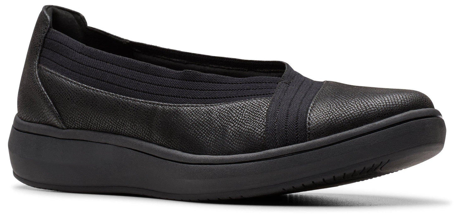 A black slip-on shoe with a low wedge heel.