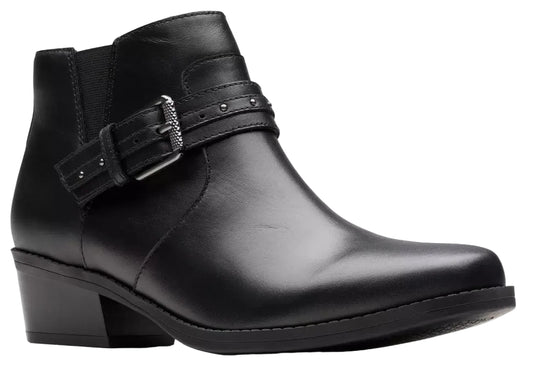 A black leather ankle boot with a low block heel, featuring a decorative strap across the ankle secured by a silver-tone buckle and accented with small metallic studs.