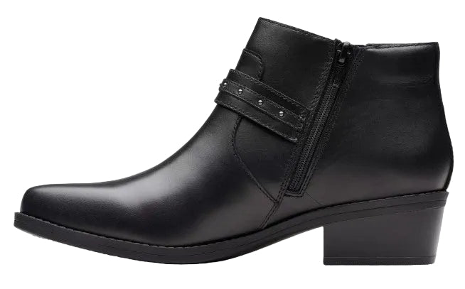 A black ankle boot with a low block heel, a side zipper closure, and a decorative strap across the ankle featuring small metallic studs.