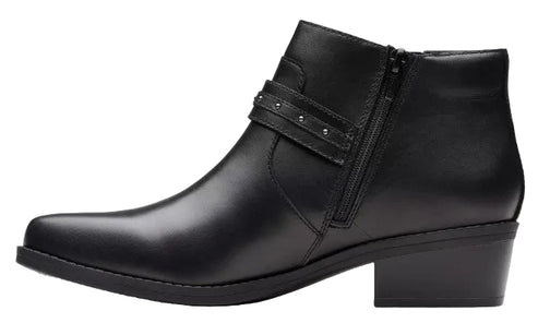 A black ankle boot with a low block heel, a side zipper closure, and a decorative strap across the ankle featuring small metallic studs.