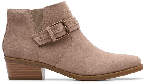 Side view of a tan suede ankle bootie with a block heel and decorative buckled strap.