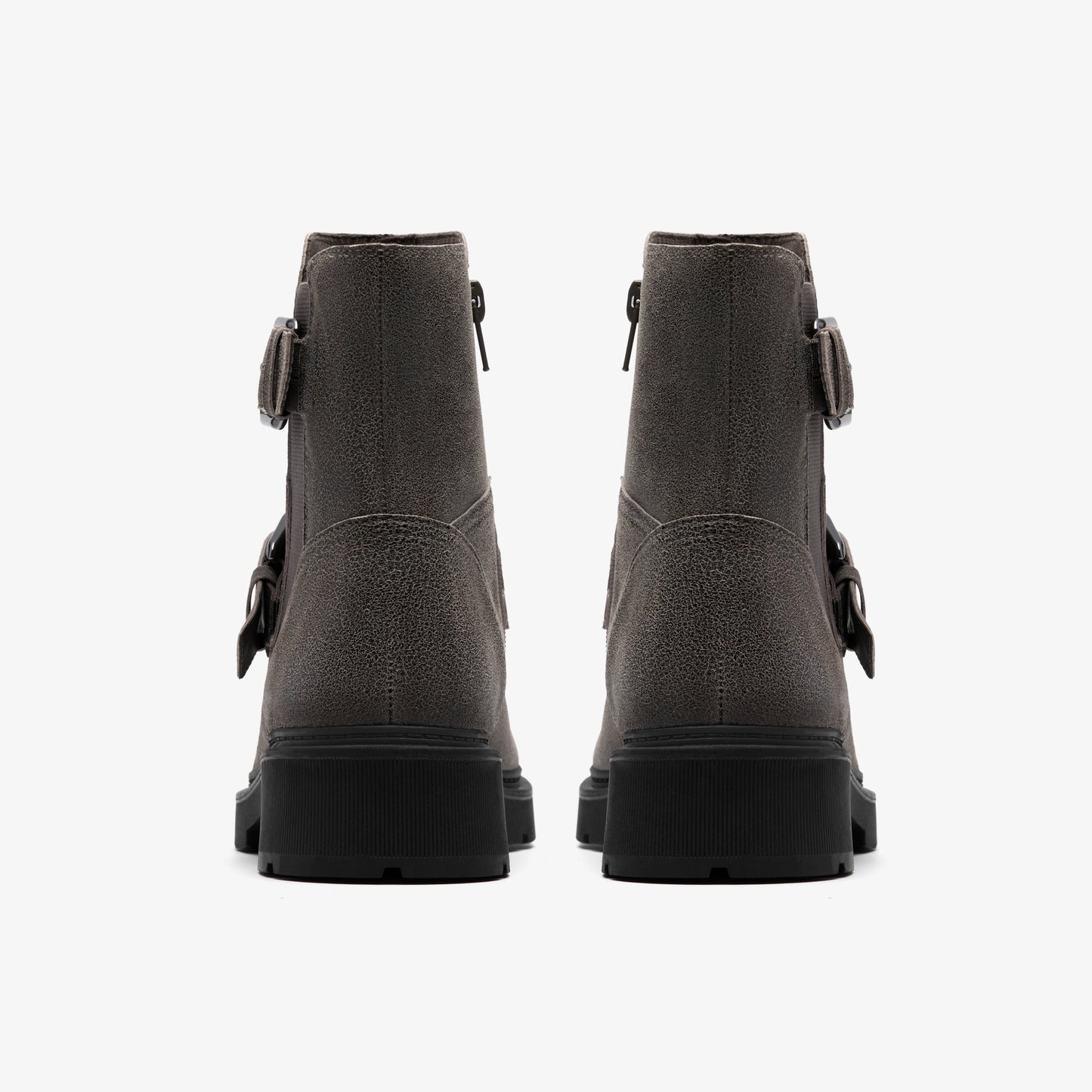 A pair of gray suede ankle boots with black lug soles and adjustable buckle straps.