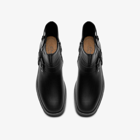 A pair of black leather ankle boots, featuring a rounded toe, a side zipper, and buckle straps.