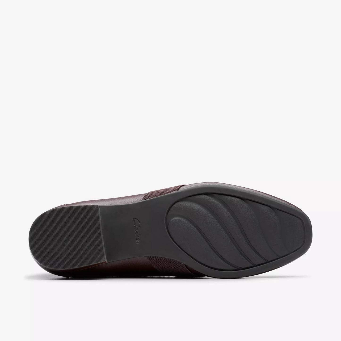 Dark brown shoe outsole with a curved, ridged design and a small heel.